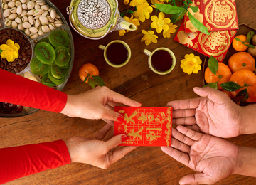 Zwei Personen übergeben sich den roten Umschlag zum chinesischen Neujahr